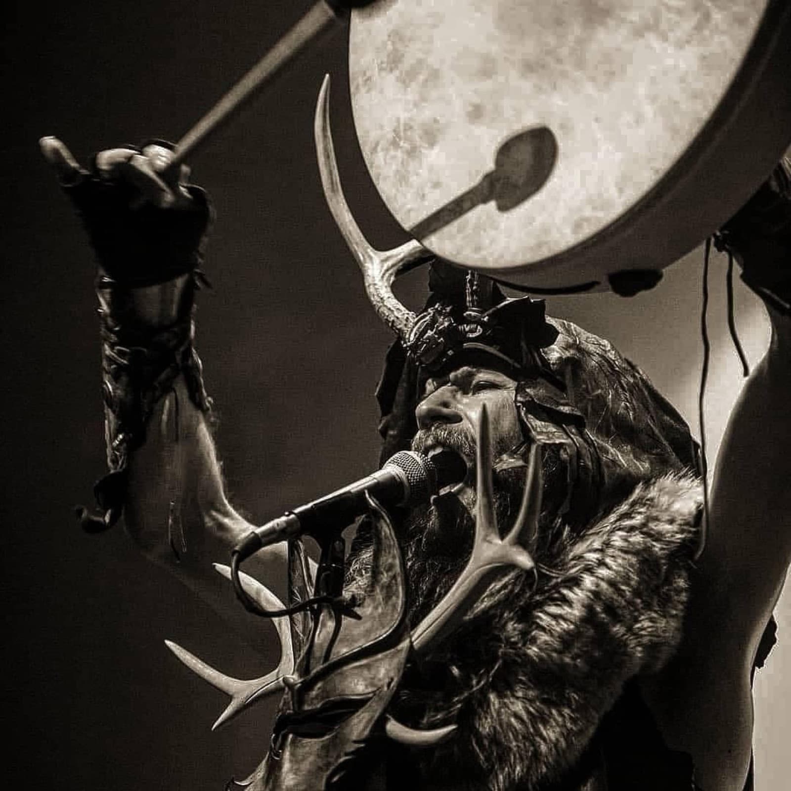 Hjeron O’Sidhe, antlered and fur-clad, drumming and chanting into the mic